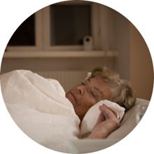 Older woman sleeping with Visit in background