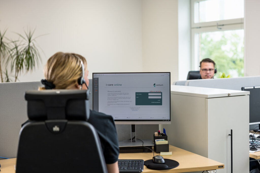 Kvinna sitter framför inlogg till i-care® online