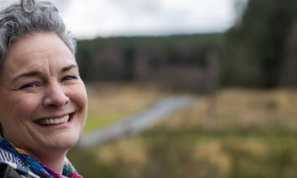 a woman smiling at the camera outside