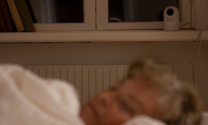 senior woman sleeping Careium camera Visit in background