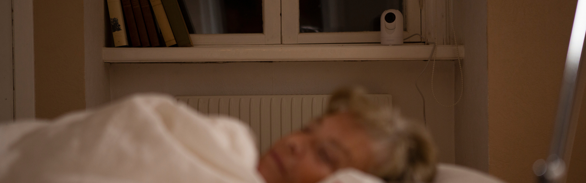 senior woman sleeping Careium camera Visit in background