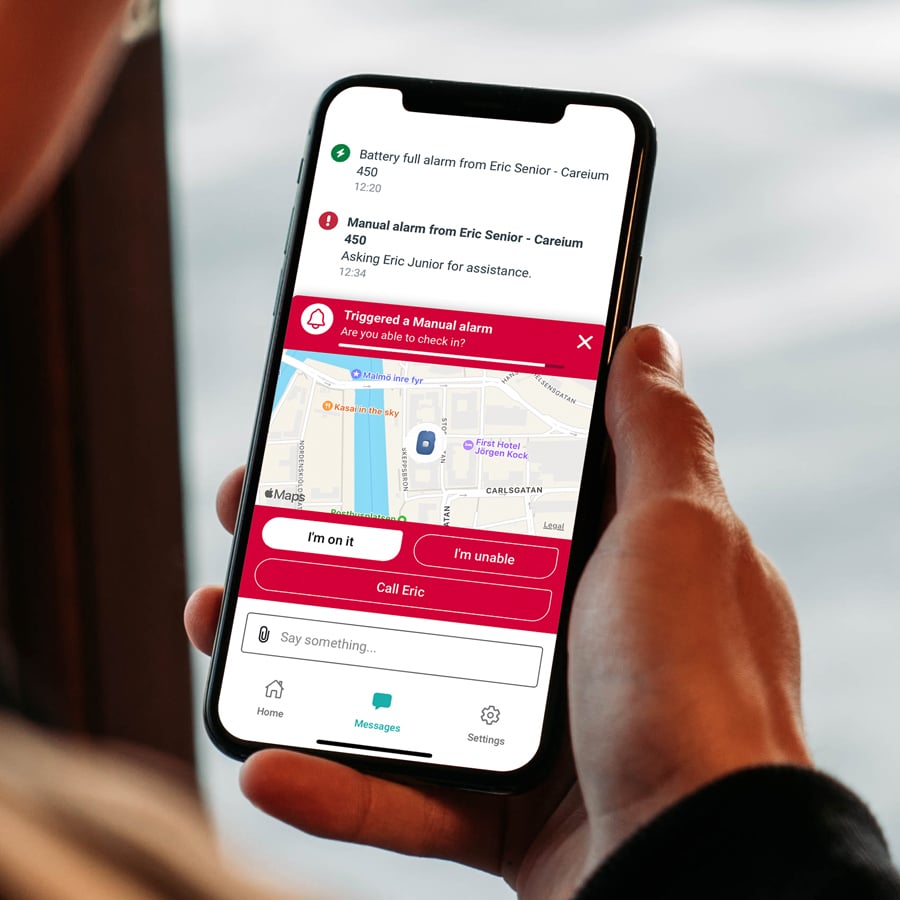 a person holding a mobile phone with the app i-care® plus