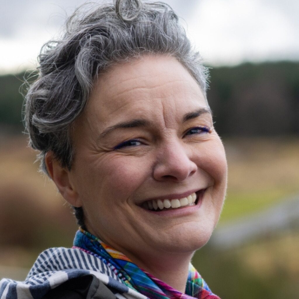 woman outdoors laughing at the camera