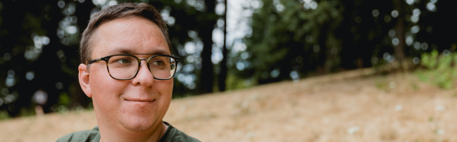 a man wearing glasses and smiling