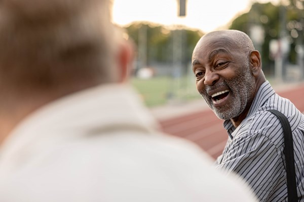 Persona mayor riéndose en un campo de fútbol