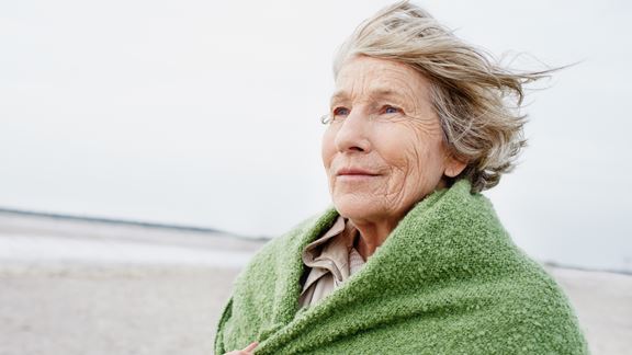 Äldre kvinna med sjal på stranden
