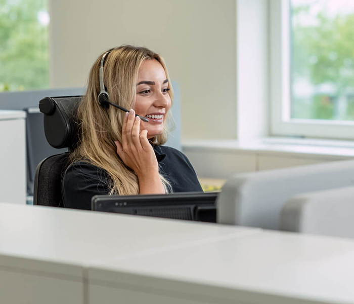 Young smiling woman with headset in alarm receiving centre