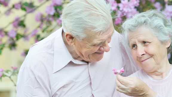 Senior couple smiling with flowers
