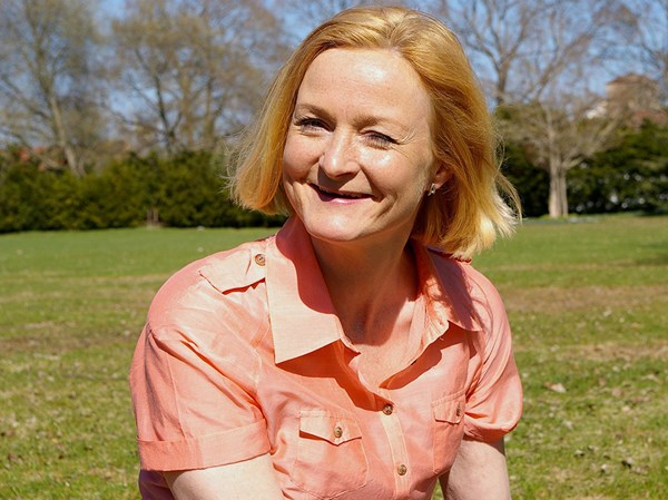 Middle aged woman smiling in a sunlit garden