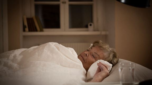 Una mujer durmiendo en la cama mientras está siendo supervisada a distancia