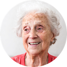 Senior kvinna med röd tröja som ler