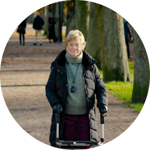 Äldre kvinna med rullator på promenad