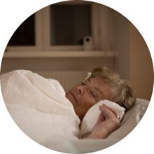 Äldre kvinna sover med Visit i bakgrunden