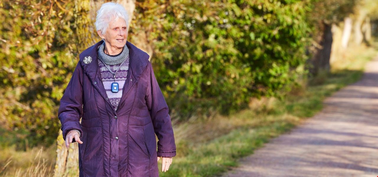 Äldre kvinna ute och promenerar. Trygghet med mobilt trygghetslarm