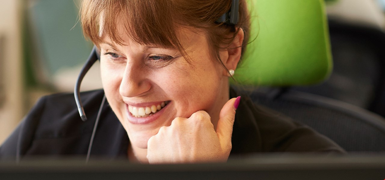 Jeune femme souriant avec casque au centre de téléassistance